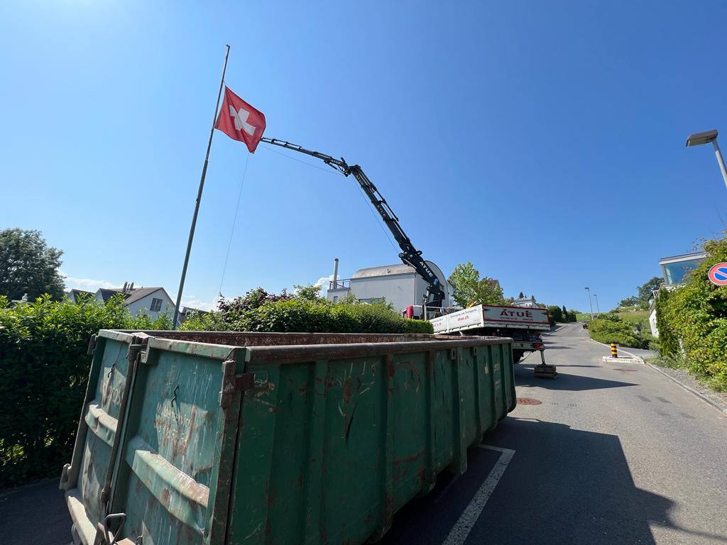 Kranwagen und Container bei einer Dachsanierung