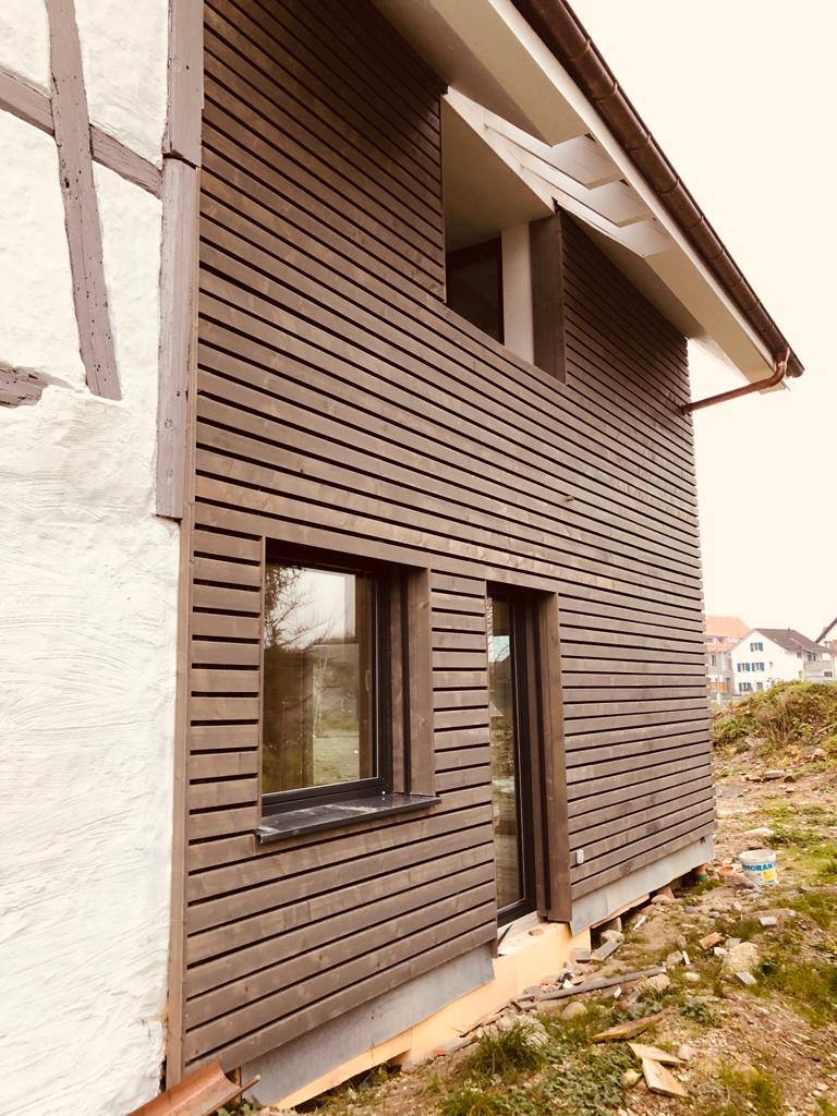 Fassade mit dunkler Holzschalung